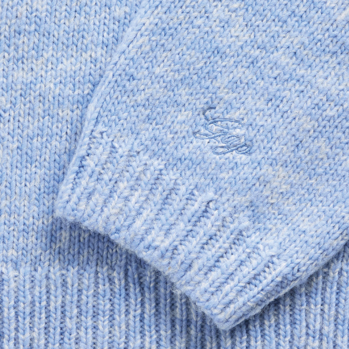 Close-up of a light blue knitted fabric with a brand logo.
