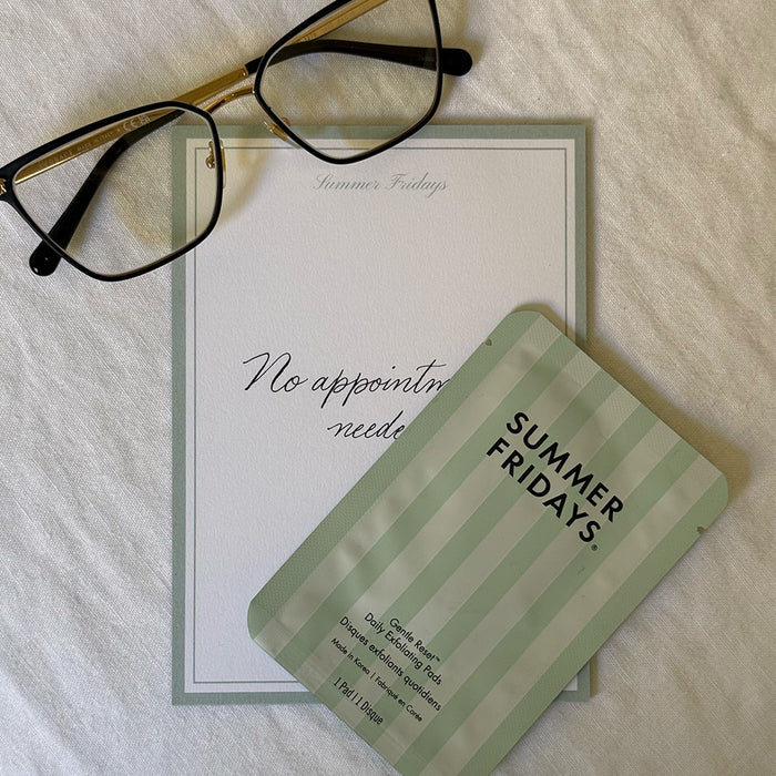 Exfoliating pads with 'Summer Fridays' branding on a white surface with glasses above it.
