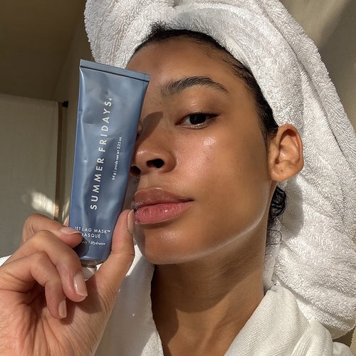Woman holding a Summer Fridays product with a towel on her head
