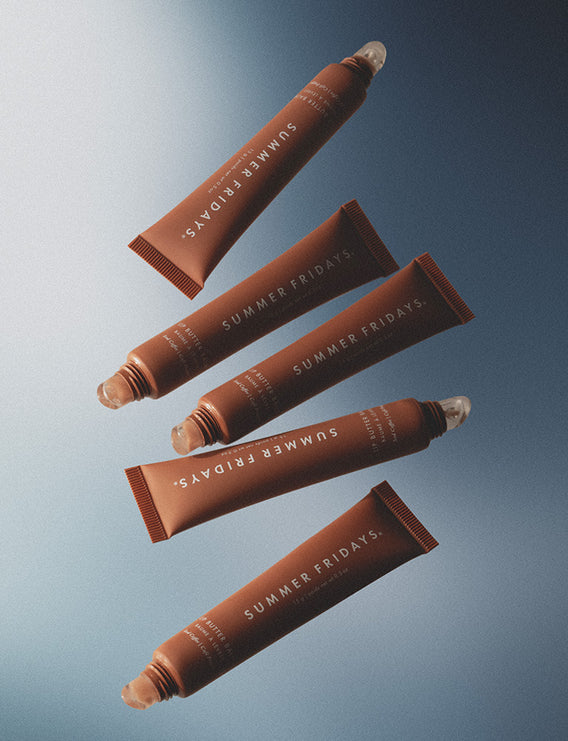 Five brown tubes of 'Summer Fridays' product on a gradient blue background